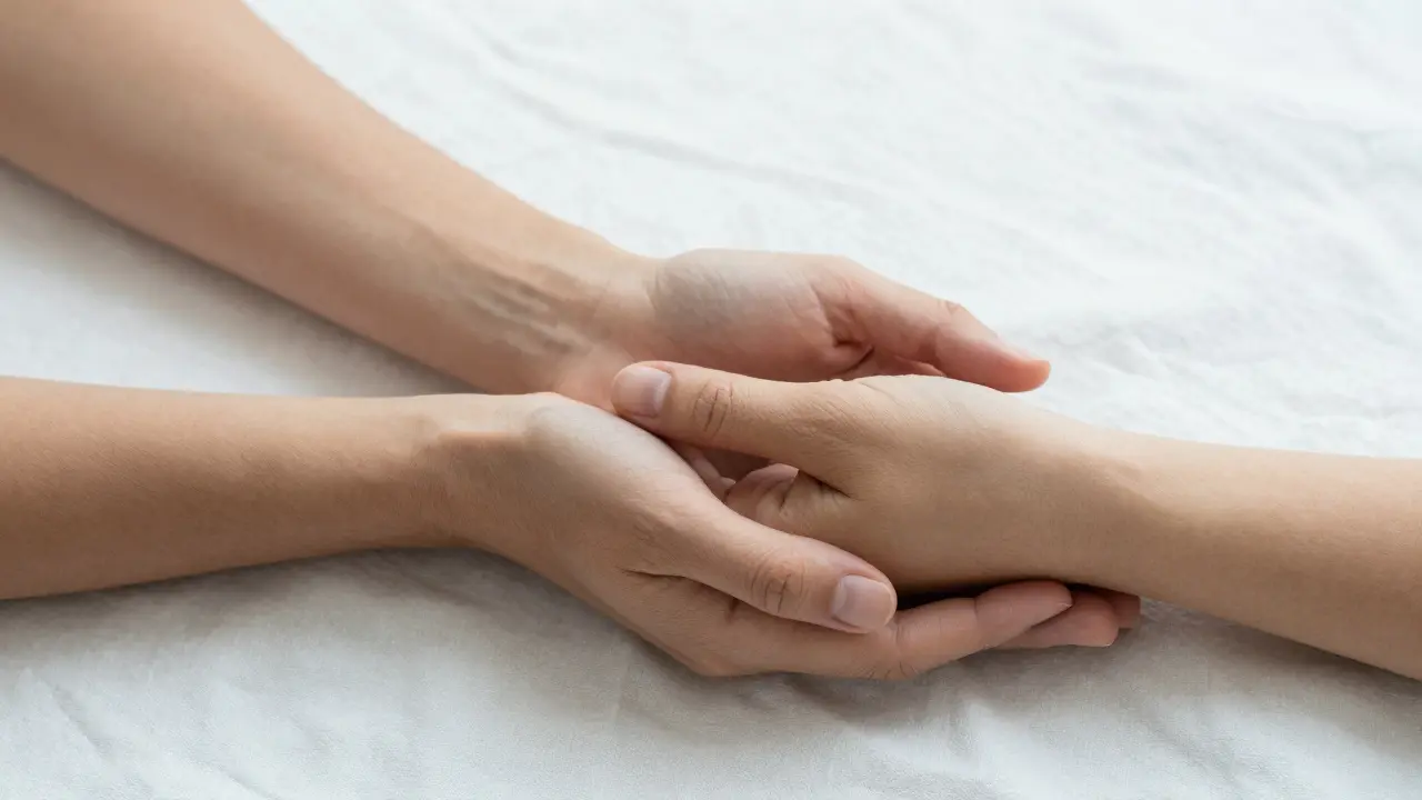 Detail jemného, terapeutického dotyku symbolizující přijetí a klid.